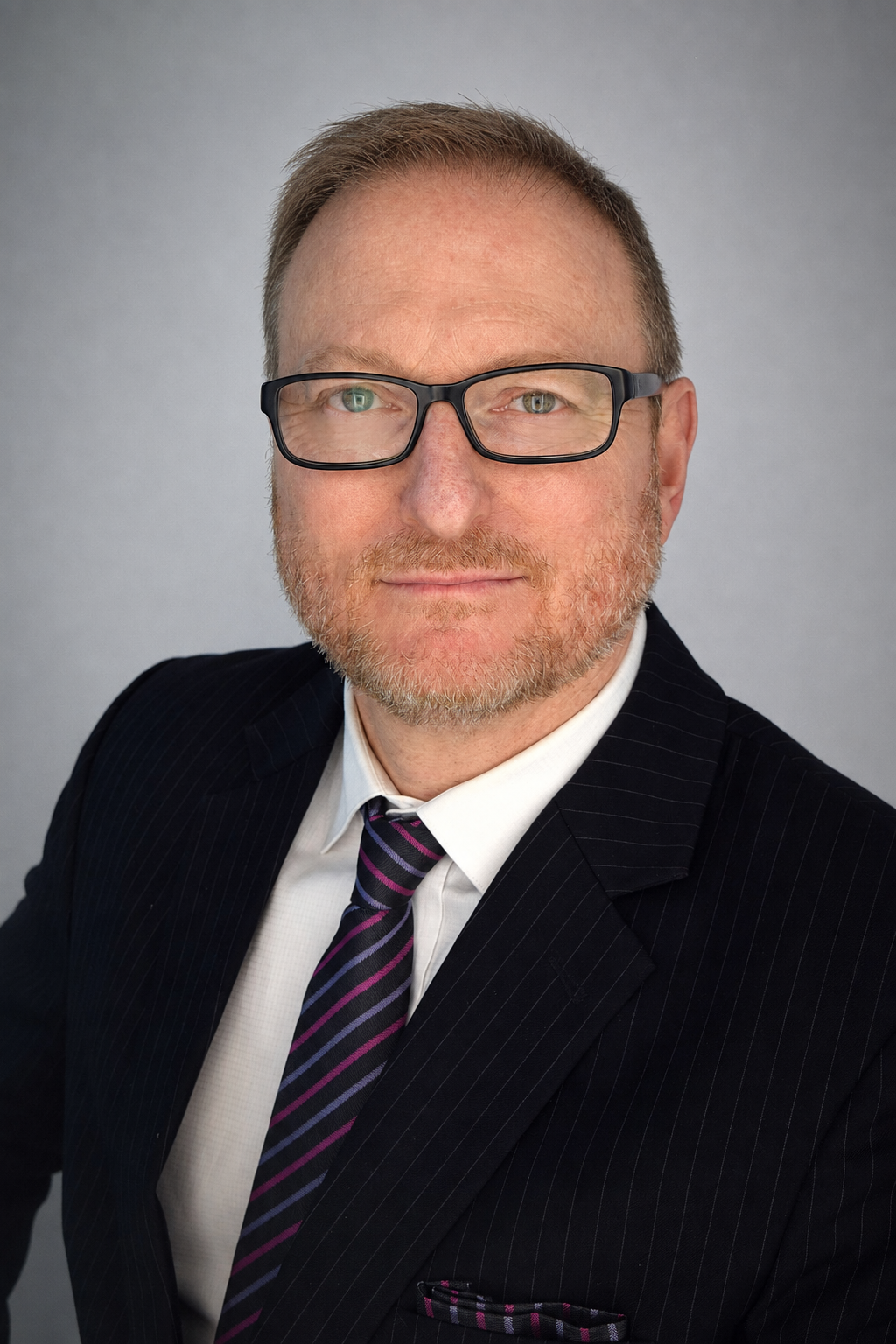 Roger Hollander in a dark suit and striped tie